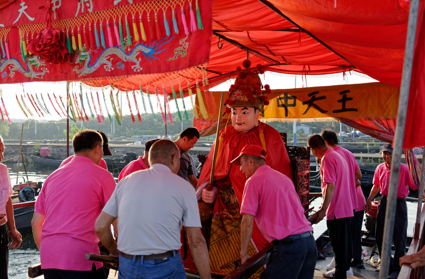 男人们围在猛将周围，准备把它抬起来。