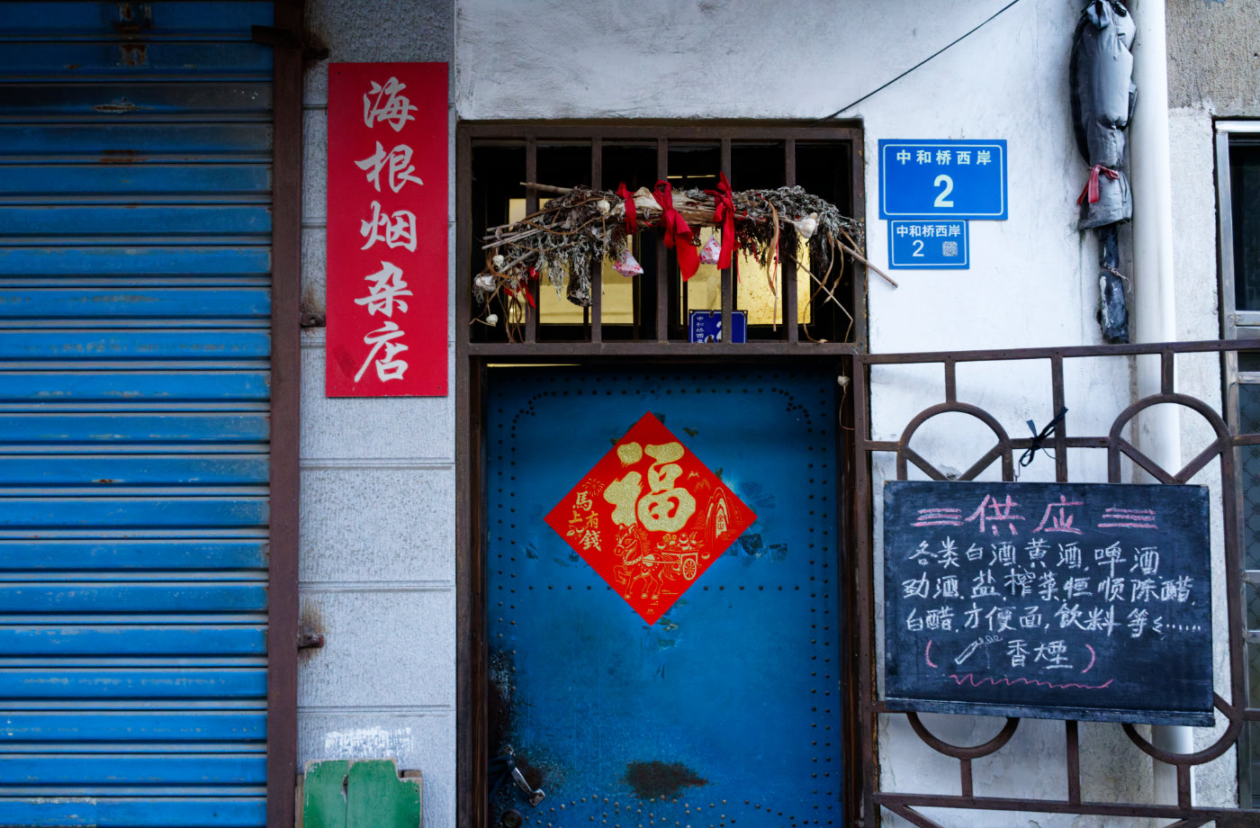 蓝色卷帘门、蓝色大门、手写供应商品，都是仍在使用的旧日常。