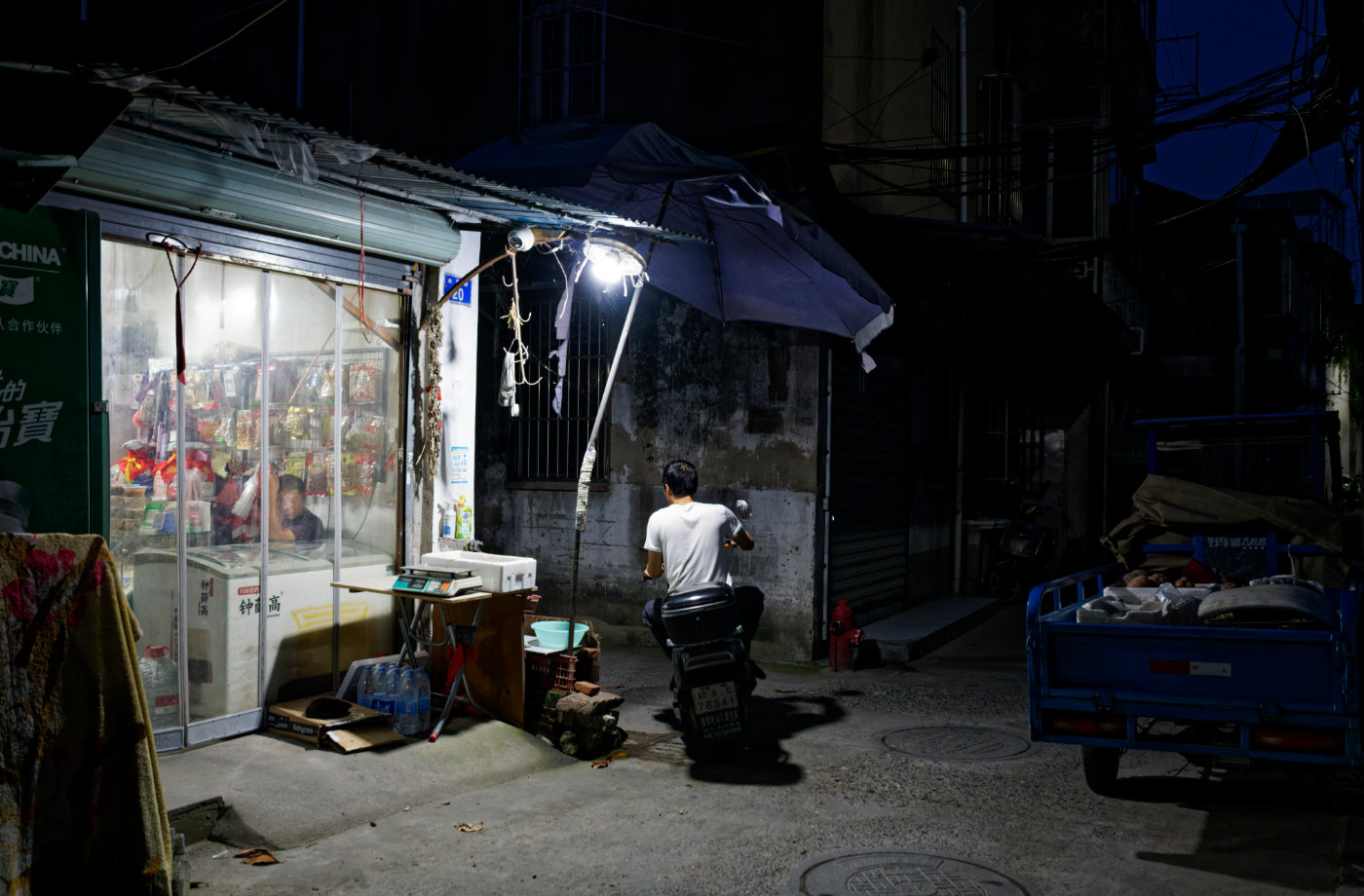 夜色落下后，小店的灯光照亮门前一小段街道。