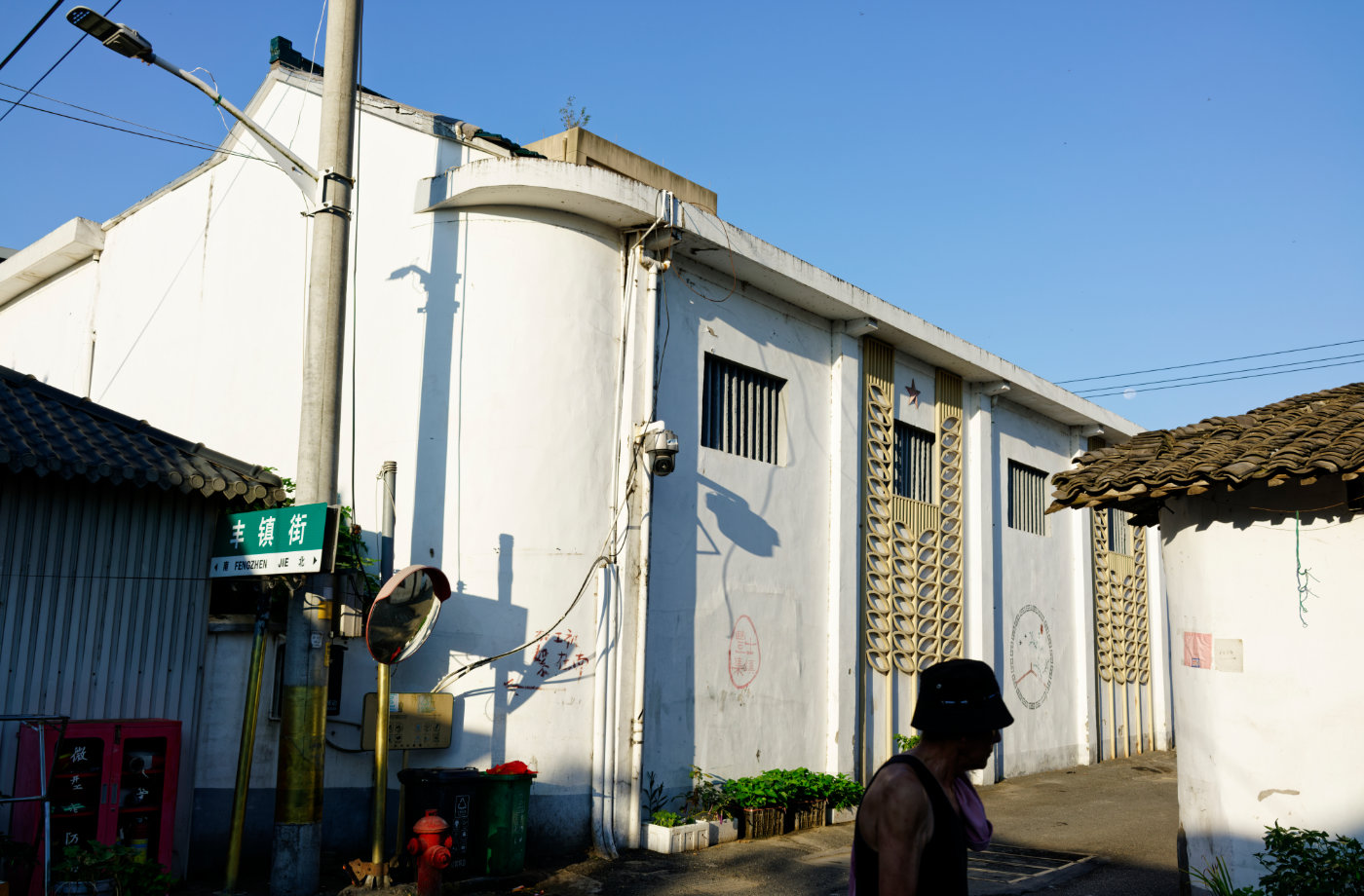 丰镇街的路牌、斜照的阳光和墙面的影子,构成老街转角处安静的一幕。