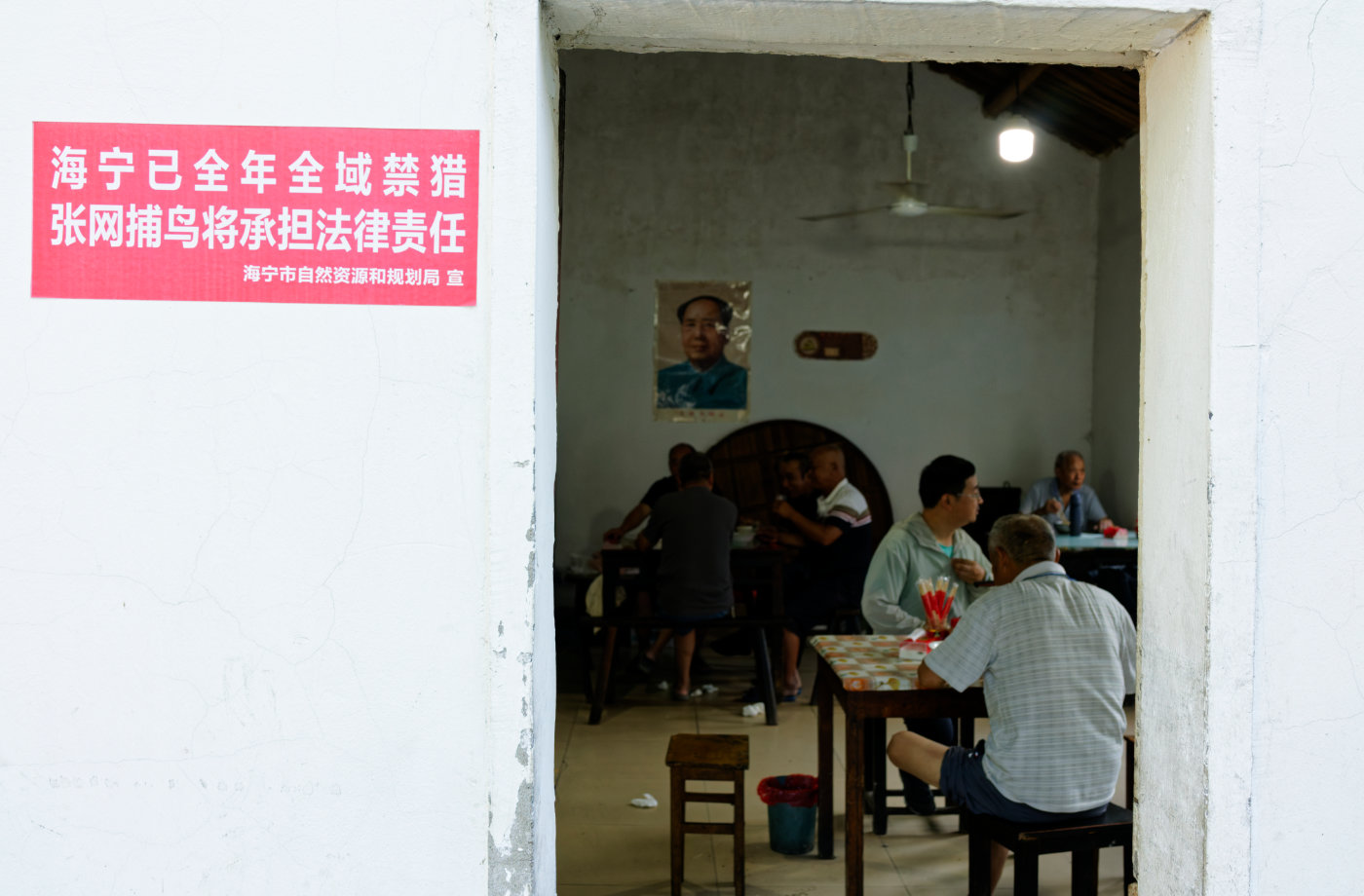 门口的红色禁猎告示之外,屋里几桌人正在吃饭聊天,老街的公共空间就这样自然展开。