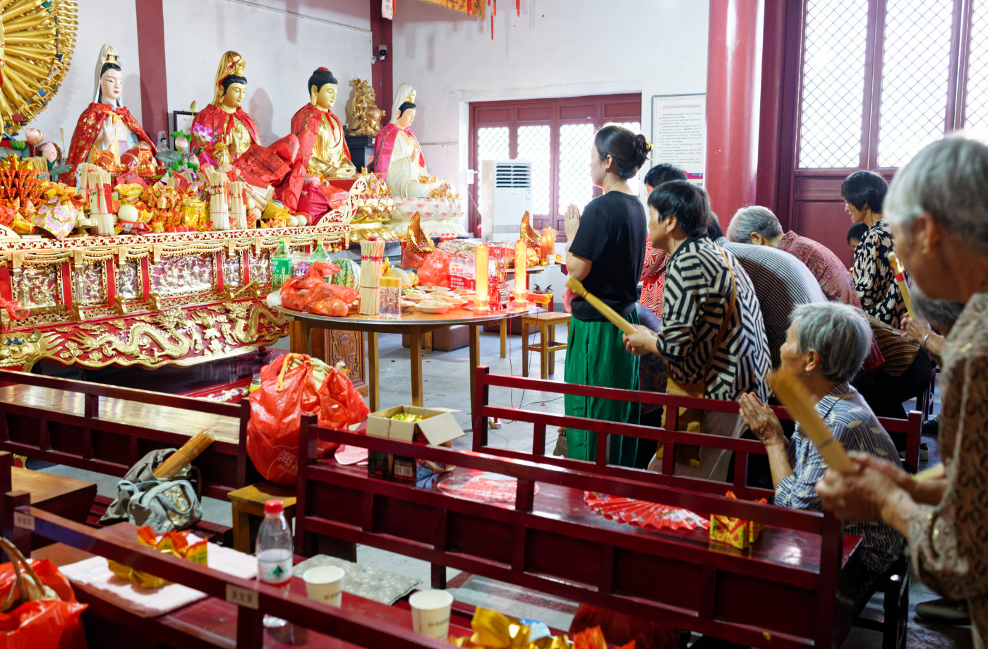 香客在神龛前礼拜,老人和年轻人共同出现在这个并不陌生的空间里。